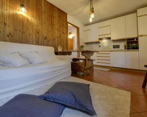 a bedroom with a large white bed and a kitchen at La Petite Maison in Pré-Saint-Didier