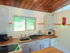 a kitchen with a sink and a microwave at Kiberick Cottage at Crackington Haven, near Bude and Boscastle, Cornwall in Bude