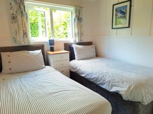 a bedroom with two beds and a window at Kiberick Cottage at Crackington Haven, near Bude and Boscastle, Cornwall in Bude