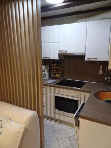 Una pequeña cocina con gabinetes blancos y un fregadero. en Piran Nono, en Piran 6 fotos más