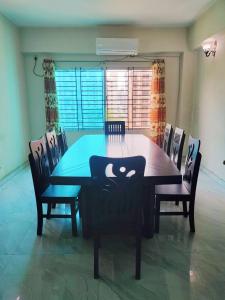 Una mesa de comedor con sillas y una mesa con asiento para gato. en Hotel Fully 富力宾馆 含早中晚中国餐, en Dhaka