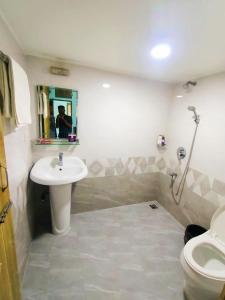 un baño con lavabo e inodoro en Hotel Fully 富力宾馆 含早中晚中国餐, en Dhaka