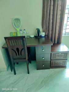 Un escritorio de madera con una silla junto a una ventana en Hotel Fully 富力宾馆 含早中晚中国餐, en Dhaka