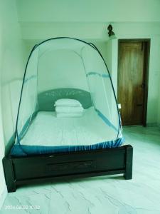 1 cama con dosel de cristal en una habitación en Hotel Fully 富力宾馆 含早中晚中国餐, en Dhaka