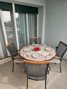 una mesa de comedor con platos y fruta. en Apartment Citadela, en Marina