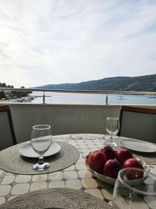 Una mesa con dos vasos y un bol de fruta. en Apartment Citadela, en Marina