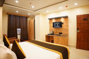 a hotel room with a bed and a tv at The MARUTINANDAN GRAND in Deoghar