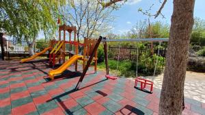 a playground with a slide and a tree at Mountain Breeze Villa in Rogachevo
