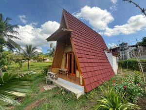 a small house with a red roof at Muni's Terrace Bungalow in Kotaraja