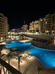 a view of a swimming pool at night at قريه اكوا فيو الساحل الشمالي in El Alamein