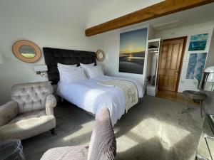 a bedroom with a large bed and a chair at Brig-y-Don in Aberdyfi