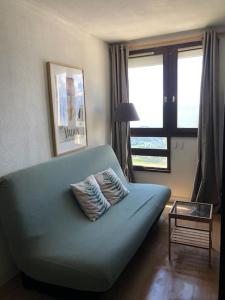 a couch with two pillows on it in a living room at Studio cosy à Prapoutel, Les 7 Laux, Alpes in Les Adrets