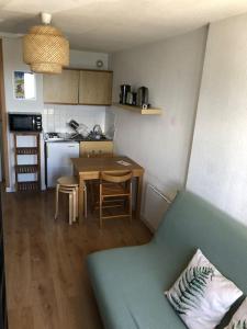 a kitchen with a blue couch and a table in a room at Studio cosy à Prapoutel, Les 7 Laux, Alpes in Les Adrets +7 photos