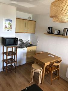 a kitchen with a wooden table and a table and chairs at Studio cosy à Prapoutel, Les 7 Laux, Alpes in Les Adrets