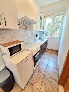 a small kitchen with a sink and a microwave at Apartments Vjeko in Split