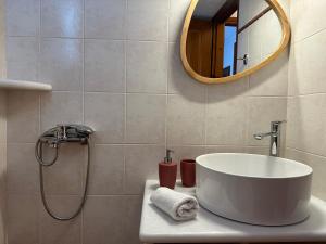 un bagno con un lavandino bianco e uno specchio di Queen bee seafront a Kampos Paros