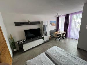 Una sala de estar con un televisor grande y una mesa. en Summit Studio, en Kaprun
