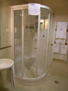 La salle de bains est pourvue d'une douche et de serviettes blanches. dans l'établissement Hotel Pombeira, à Guarda