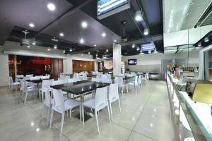 a dining room with white chairs and tables in a restaurant at Bahagia Hotel Langkawi in Kuah