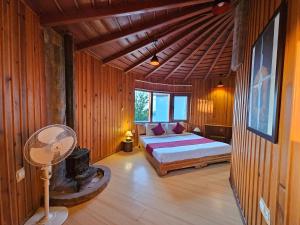 a bedroom with a bed and a fan in a room at The Vanya, Boutique Stay in Rāmgarh +18 photos