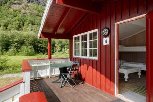 una cabina rossa con un tavolo su un ponte di Utladalen Camping ad Årdal