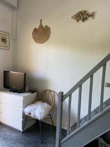 a room with a staircase with a tv and a chair at Corse Calvi appt coté Mer in Calvi