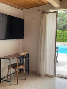 a room with a table and a television on the wall at Magnifique studio, piscine, parking Nice in Nice
