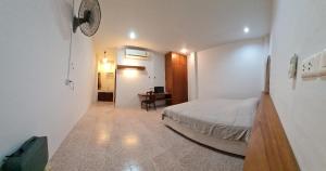 a bedroom with a bed and a desk in a room at Banchang home village L in Ban Phayun