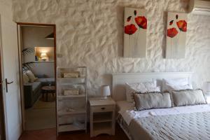 a bedroom with a bed with two paintings on the wall at Kalpic Suites & Villa in Lozovac
