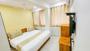 a small bedroom with a bed and a television at Hotel Nova Safal in Rajkot