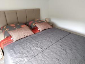 una cama con dos almohadas encima en Apartman Ivano, en Krnica