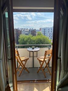 a balcony with a table and chairs on a balcony at Cozy City Appartement Warszawa in Warsaw