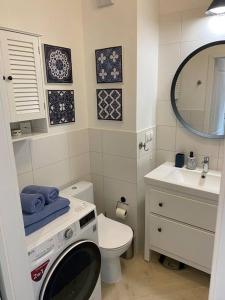 a bathroom with a sink and a toilet and a mirror at Cozy City Appartement Warszawa in Warsaw +6 photos