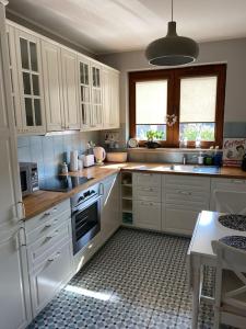 a kitchen with white cabinets and a stove top oven at Cozy City Appartement Warszawa in Warsaw
