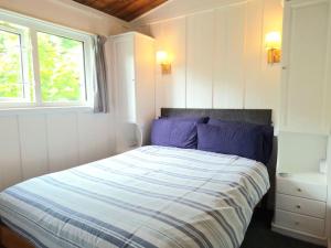 une chambre avec un lit avec une couette bleue et une fenêtre dans l'établissement Rusey Cottage at Crackington Haven, near Bude and Boscastle, Cornwall, à Bude