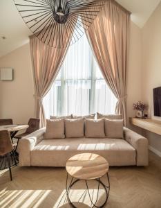 een woonkamer met een bank en een groot raam bij LightSummerPalanga in Palanga