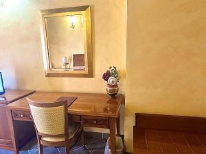 a desk with a mirror and a table with chairs at Palazzo Marzano in Briatico