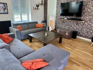 a living room with two couches and a tv at Chez Gus - 10 personnes - BCLA in Arnage