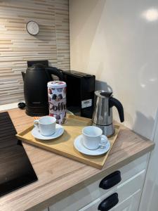 een dienblad met twee kopjes en een koffiezetapparaat op een aanrecht bij Camilla's home in Turijn