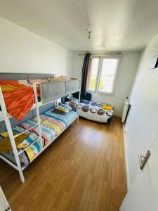 a room with two bunk beds and a wooden floor at 8N Apartment group near Paris in Bondy +8 photos