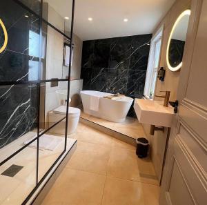 a bathroom with a tub and a toilet and a sink at The Parr’s Bank Hotel in Warrington