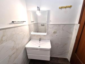 ein weißes Badezimmer mit Waschbecken und Spiegel in der Unterkunft ROSSO - PROPPRO SRL - MILAZZO ISOLE EOLIEe in Milazzo