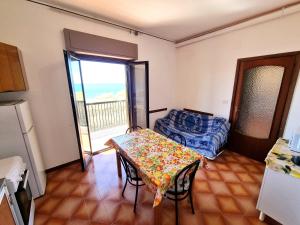 ein kleines Zimmer mit einem Tisch und einer Küche in der Unterkunft ROSSO - PROPPRO SRL - MILAZZO ISOLE EOLIEe in Milazzo