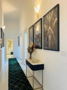 corridoio con tavolo e quadri alle pareti di Dulcamara Boutique Apartments - MAISON DÈCO a Bari