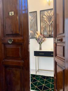 una porta di legno con un vaso di fiori su un bancone di Dulcamara Boutique Apartments - MAISON DÈCO a Bari