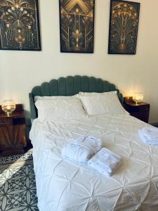 un grande letto bianco con due asciugamani sopra di Dulcamara Boutique Apartments - MAISON DÈCO a Bari Altre 19 foto