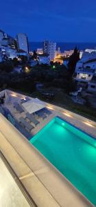 a swimming pool on the roof of a building at night at Elia Hotel Residence in Budva
