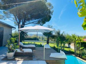 a patio with an umbrella and a pool at Le Zingaro in Busque