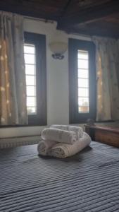 a room with three towels on the floor with two windows at Guesthouse Eleni in Palaios Panteleimonas +21 photos