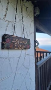 a sign hanging on the side of a building at Guesthouse Eleni in Palaios Panteleimon